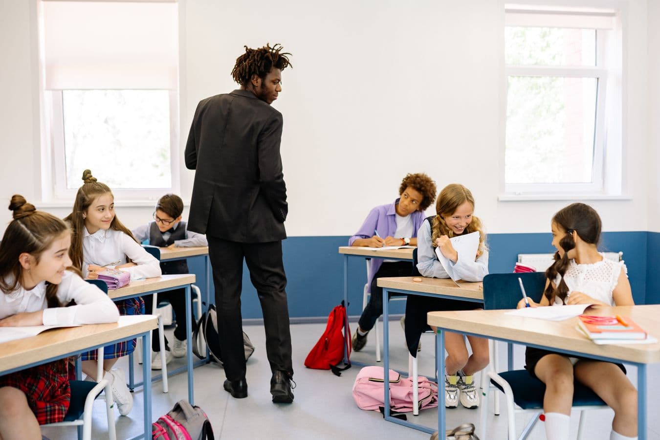 Teacher standing among students in a classroom