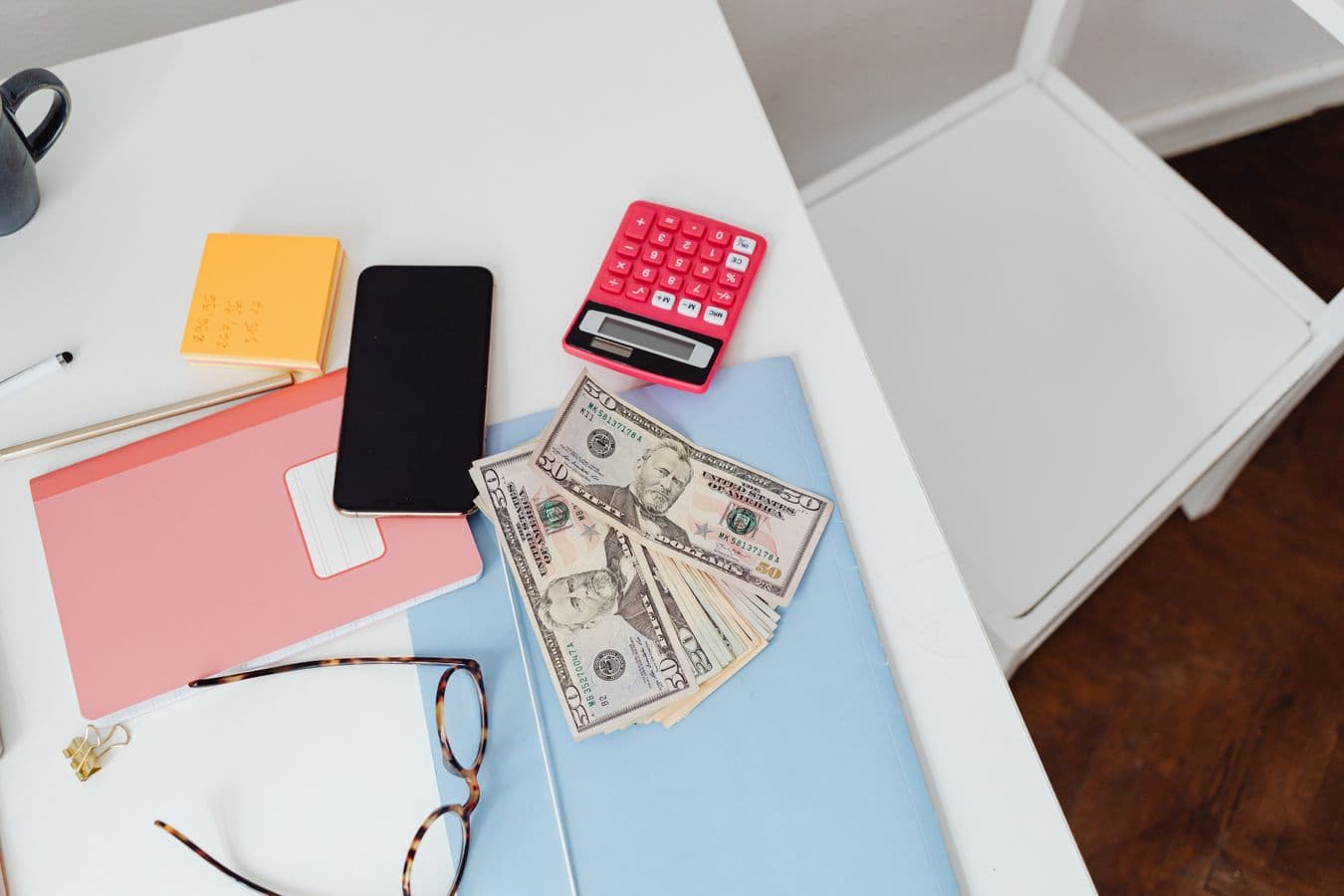 Calculator and bills on a table representing college financial planning